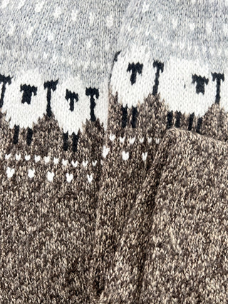Détail de la bordure jacquard sur pull en tricot gris, points et frises contrastées
