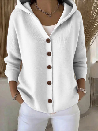 Cardigan en tricot blanc à capuche, boutons marron, devant boutonné, poignets côtelés.