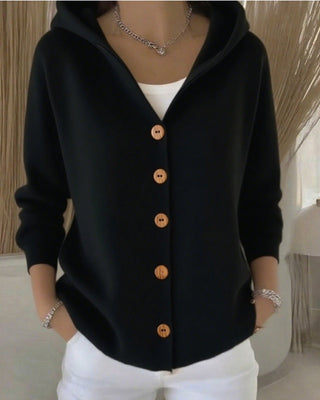 Cardigan en tricot noir à capuche, boutons marron sur le devant, poignets côtelés.
