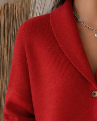 Cardigan en tricot rouge à col polo, texture du tricot et boutons visibles.