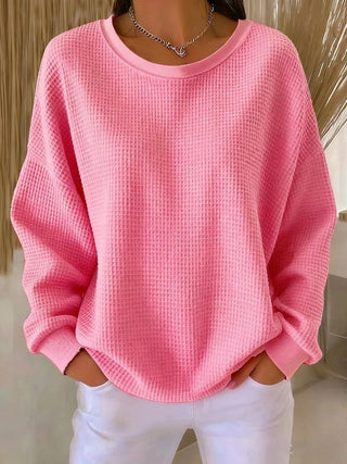 Pull long femme en tricot gaufré rose, manches longues, col rond.