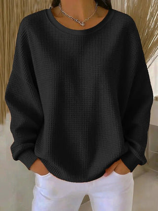 Pull long femme en tricot gaufré noir, manches longues, col rond.